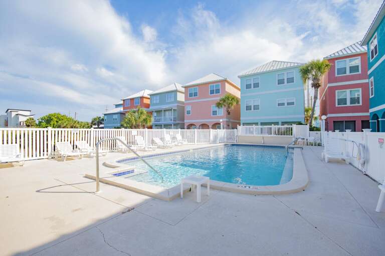 Sun-soaked pool area with vibrant colorful townhouses nearby