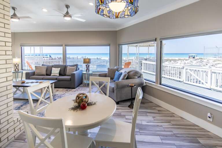 Sunlit living and dining area with panoramic water views