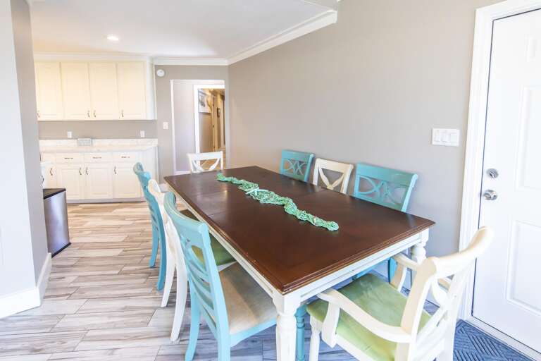 Bright dining area with seating for eight and open kitchen view