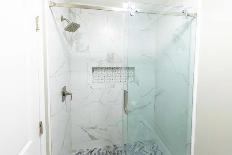 Spa-like glass shower with elegant marble tile detailing
