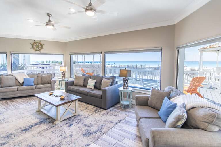 Spacious living room with panoramic waterfront views and cozy seating
