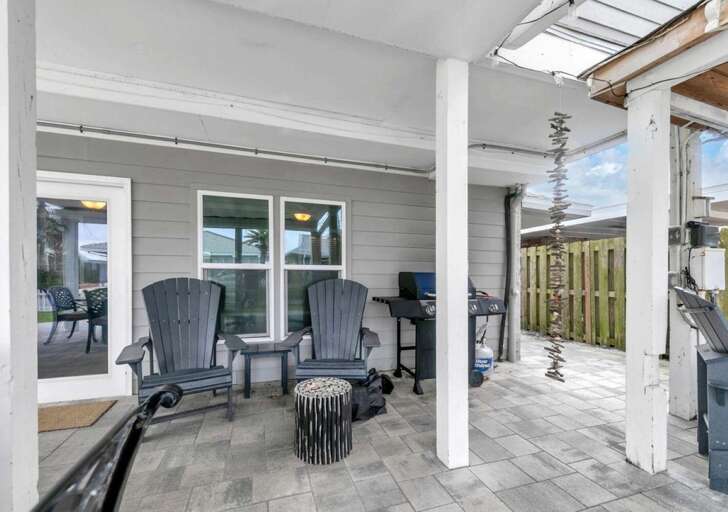 Cozy covered patio with comfortable seating and outdoor grill