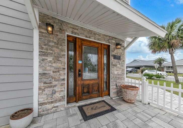 Welcoming front porch with elegant stone accents and warm lighting
