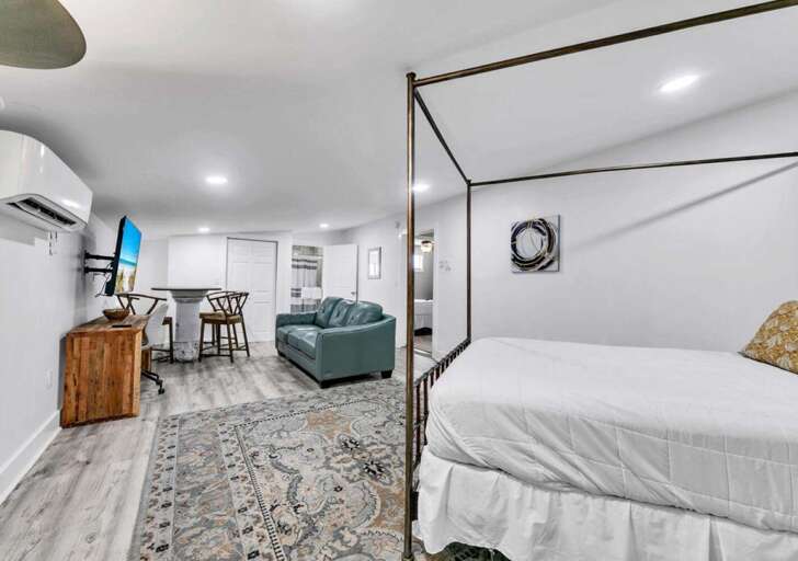 Spacious open-concept studio with cozy four-poster bed and modern comforts