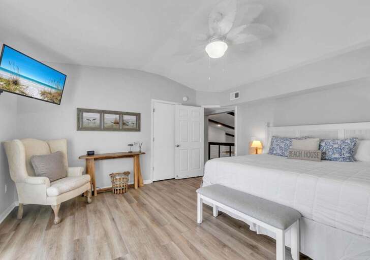 Bright and airy bedroom with cozy seating and workspace