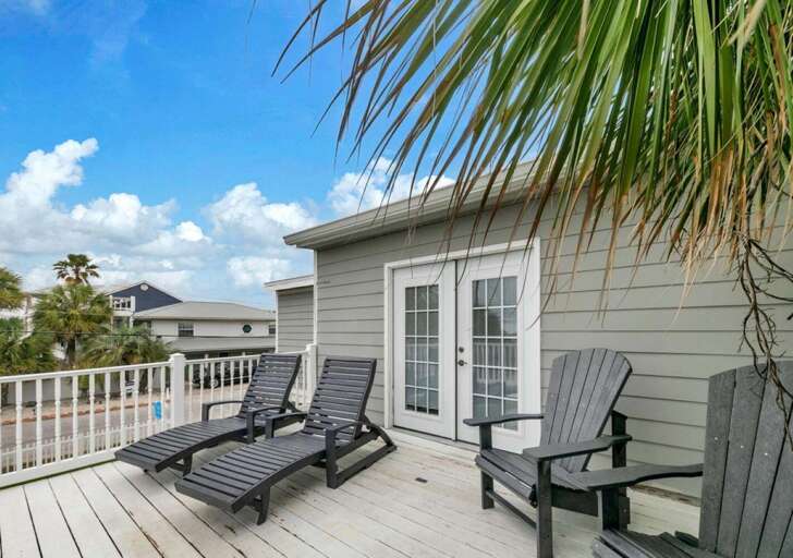 Sun-soaked deck with loungers and cozy seating area
