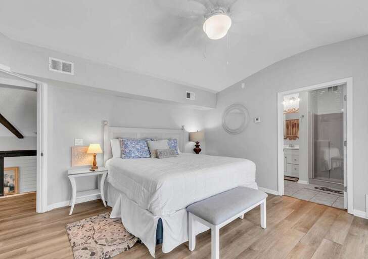 Bright and airy bedroom with cozy seating and modern accents