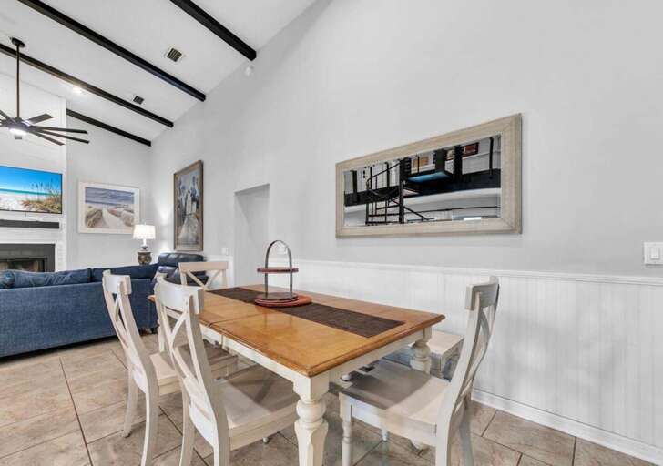 Bright dining area with vaulted ceilings and coastal views
