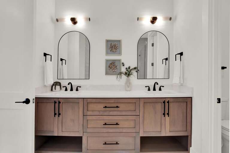 Bright, modern bathroom with dual vanities and elegant mirrors