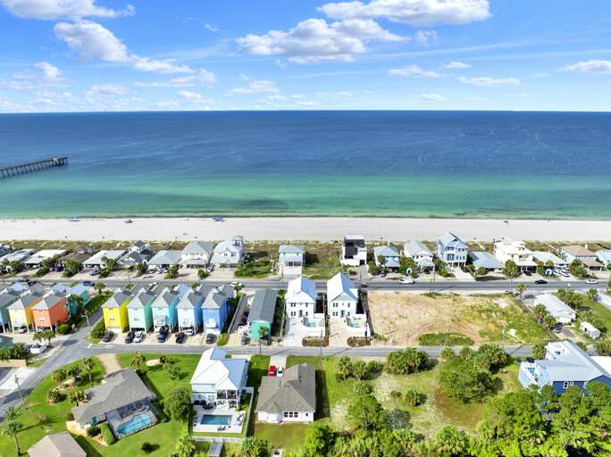 Oceanfront view with colorful beach cottages and sandy shore