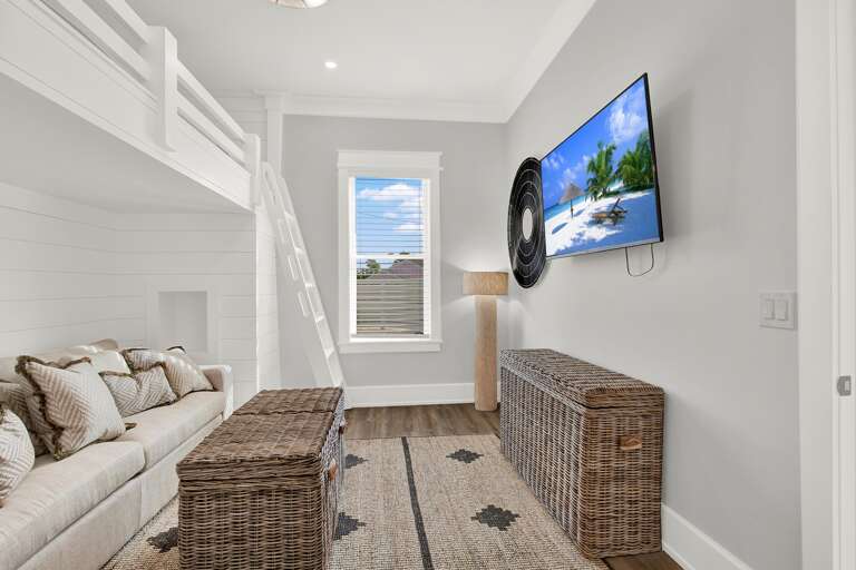 Cozy bunk room with smart TV and natural light