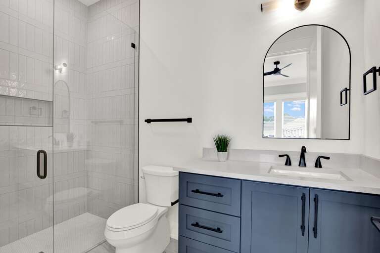Modern bathroom with sleek glass shower and navy vanity