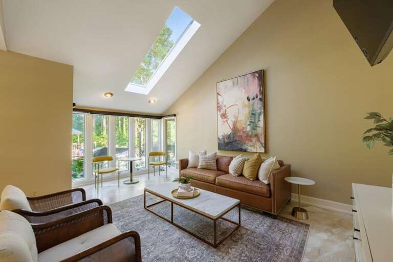 Sunlit living room with cozy seating and garden views