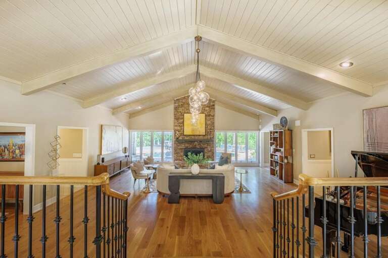 Spacious vaulted living room with warm hardwood floors and natural light