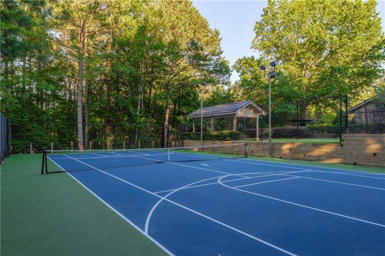Private tennis court surrounded by lush greenery for active fun