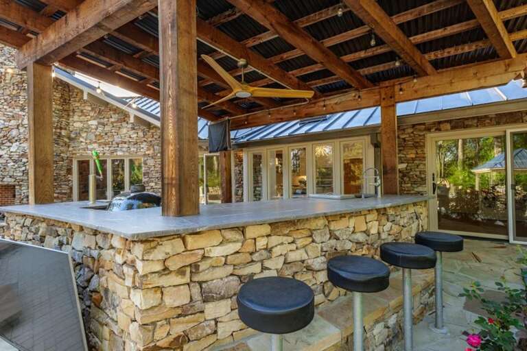 Rustic outdoor bar with stone accents and cozy seating