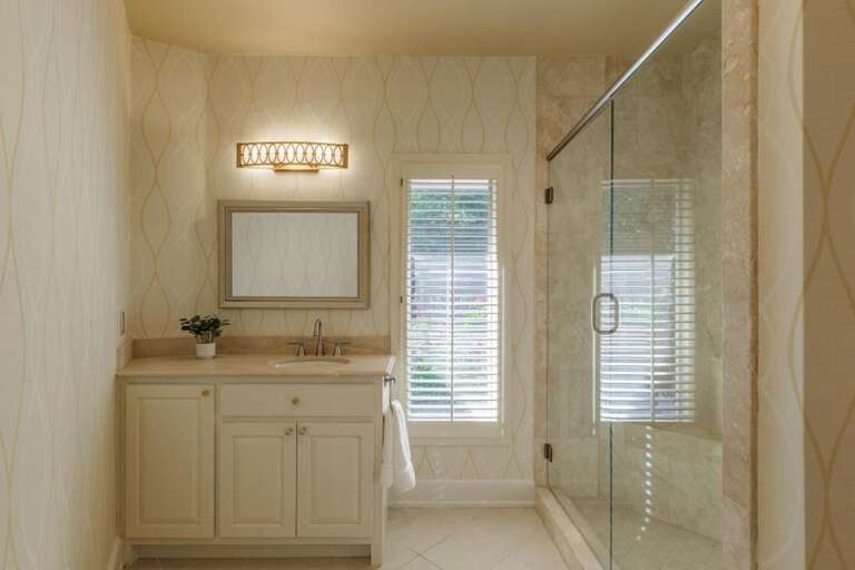 Bright bathroom with glass shower and natural light