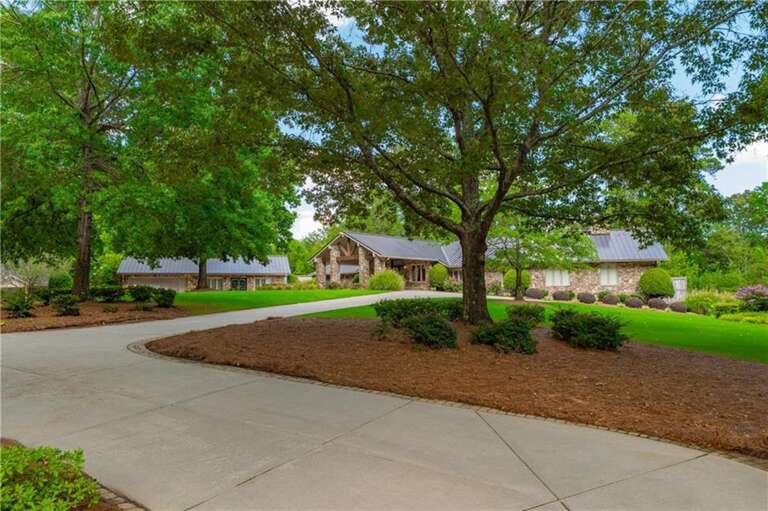 Shaded driveway leading to a spacious, welcoming home