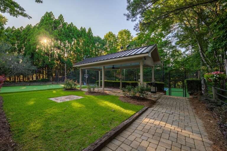 Spacious backyard with covered patio and lush greenery
