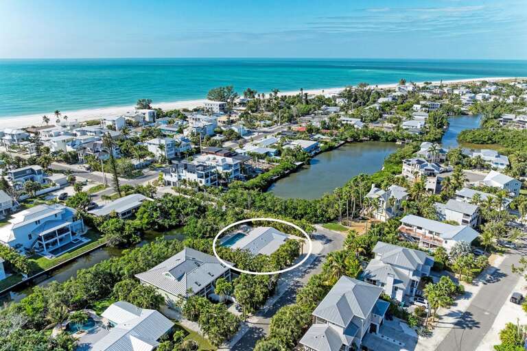 Aerial View Of Coastal Community With Circled Structure Near Beach And Lagoon