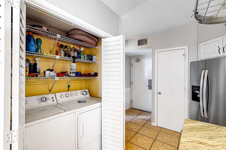 Laundry is located on the wall between the kitchen and dining