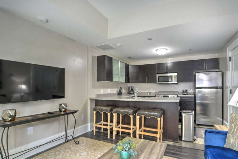 Spacious Vacation Rental Living Area With Kitchen Bar And Wooden Stools