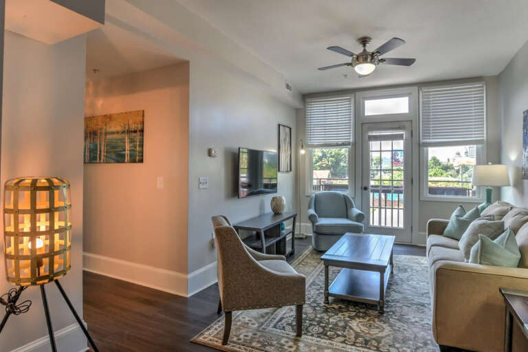 Bright Room With Beige Sofa, Light Lamp, Glass Doors To Balcony