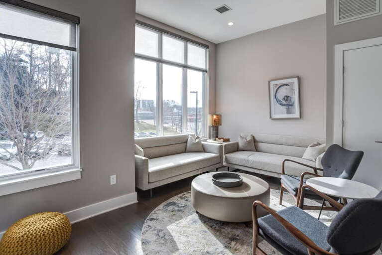 Vacation Rental Room With Large Windows, Light Walls, And Various Seating