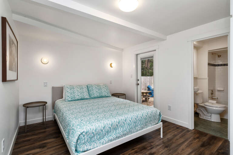 Downstairs master bedroom with attached bath and queen bed and door to outdoor deck and back yard Downstairs master bedroom with attached bath and queen bed and door to outdoor deck and back yard