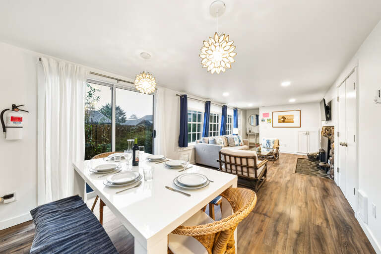 Dining room open to living space with woodstove, smart Tv, and access to front deck.