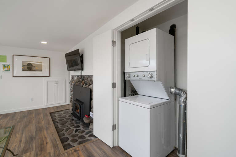 HUMMINGBIRD COTTAGE- Laundry with stackable washer/dryer.  Living room with ROKU Smart TV, Woodstove fireplace, open to dining area. HUMMINGBIRD COTTAGE- Laundry with stackable washer/dryer.  Living room with ROKU Smart TV, Woodstove fireplace, open to dining area.