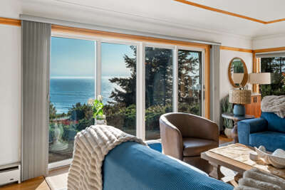 Beautiful coastline views from the living area on the main floor. With a wood burning fireplace, comfortable sleeper sofa. Flat screen TV,  and incredible ocean views.