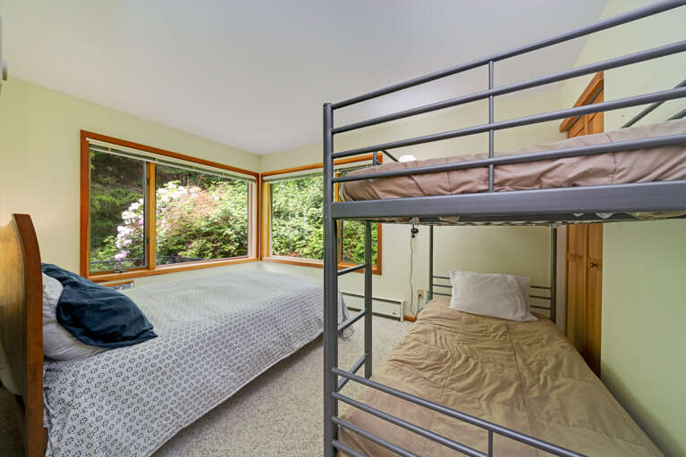 Queen bedroom with a set of twin bunks, views of the back yard area. 