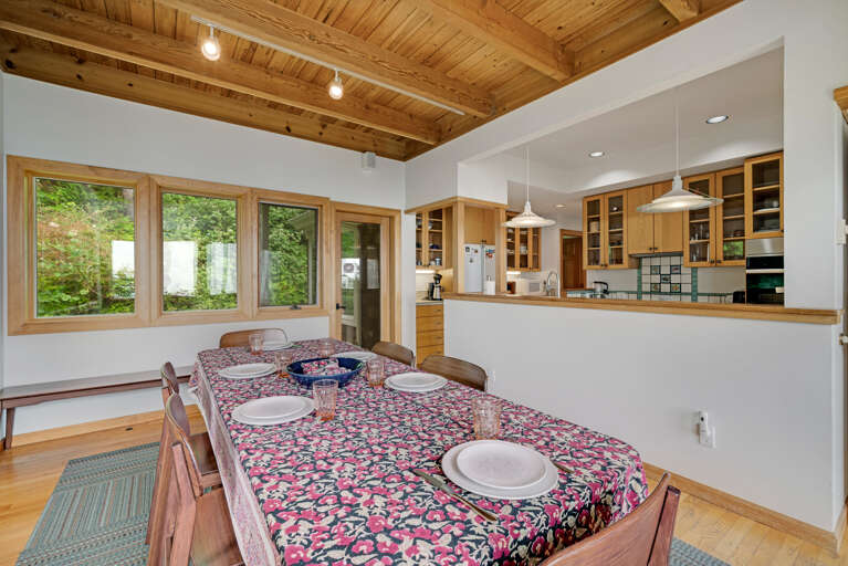 Dining room with additional bench seating, Ocean views, and access to the fenced yard area.