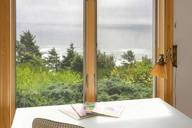 Master bedroom with a king bed, desk area, lounging chair, walk in closet, and master bath with sit down shower and dual sinks with spectacular views. 