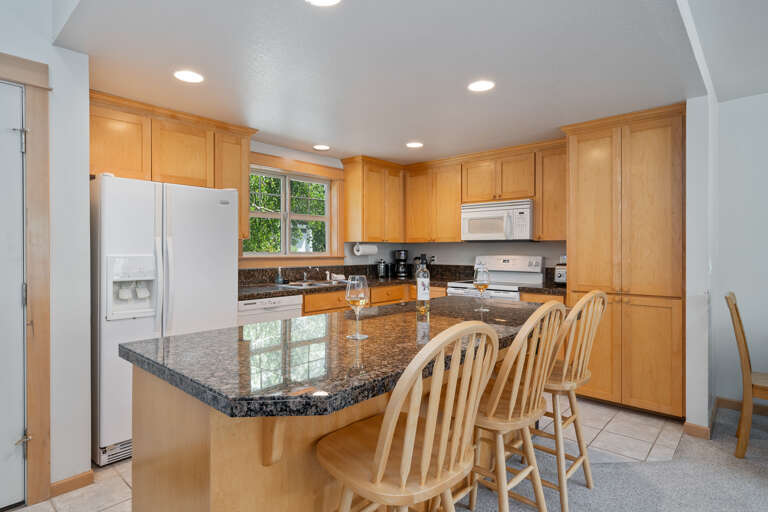 Fully equipped kitchen with breakfast bar, open to dining and living area with gas fireplace Fully equipped kitchen with breakfast bar, open to dining and living area with gas fireplace