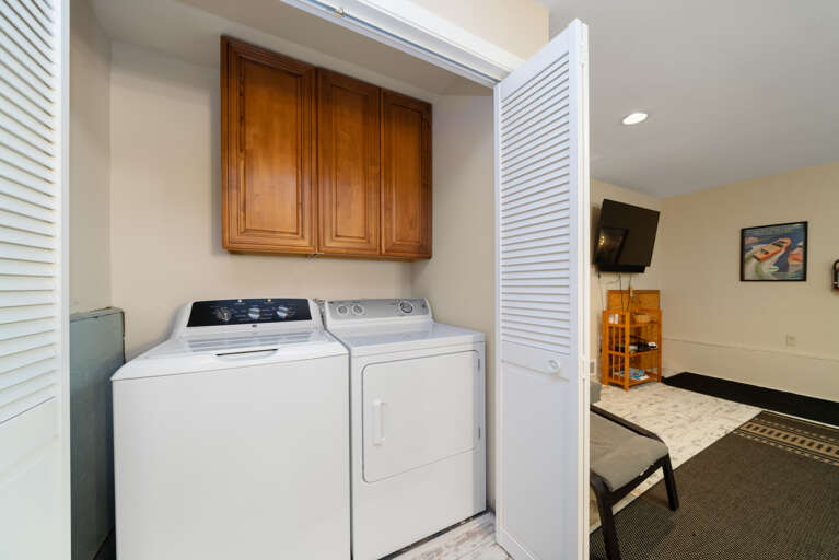 Den with a leather lounging couch that doubles as a twin sleeper. Desk and monitor, Smart TV, and laundry with washer and dryer. 