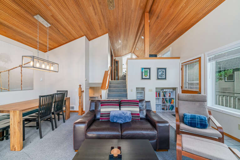 Living/dining room with woodstove and access to front deck with BBQ and outdoor furniture.