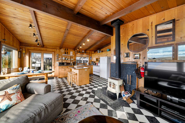 Classic lodge style feel with woodstove, smart TV, and open to the kitchen and dining area.