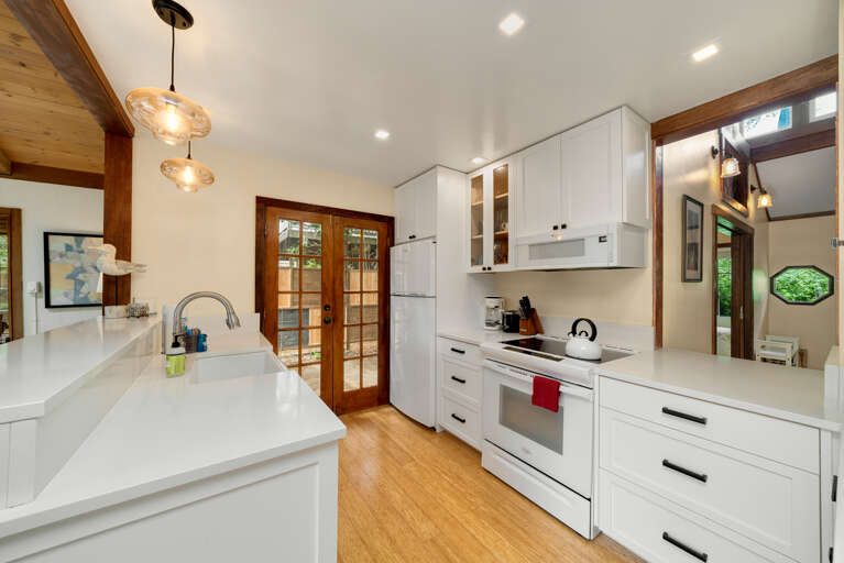 Fully equipped kitchen with side yard access to Gas BBQ. Open to the living area.