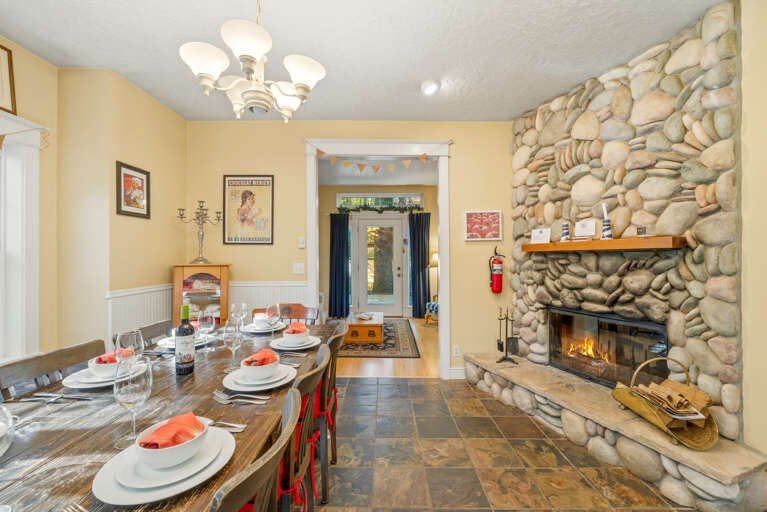 Wood burning double sided fireplace, dining table and open kitchen area.