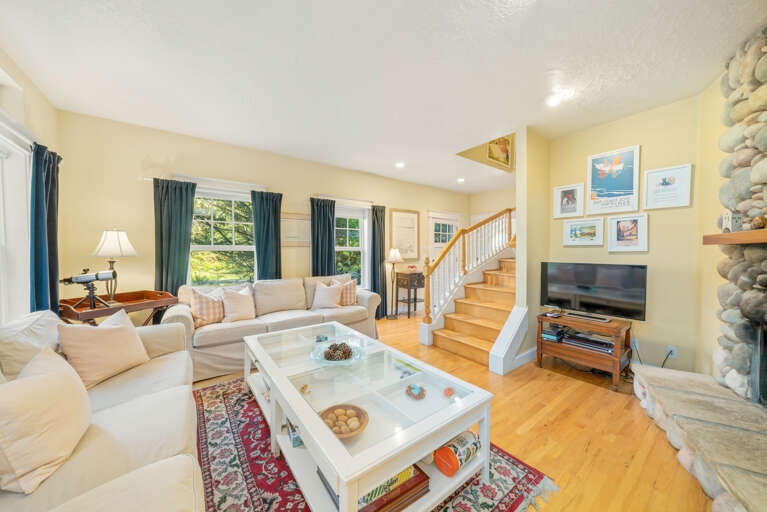 Living room with access to upstairs, double sided wood fireplace, Cable and Streaming TV 