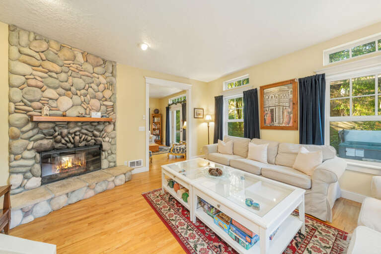 Living room with access to upstairs, double sided wood fireplace, Cable and Streaming TV 