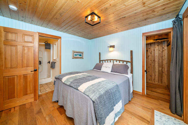Master bedroom with queen bed and attached bath with walk in shower