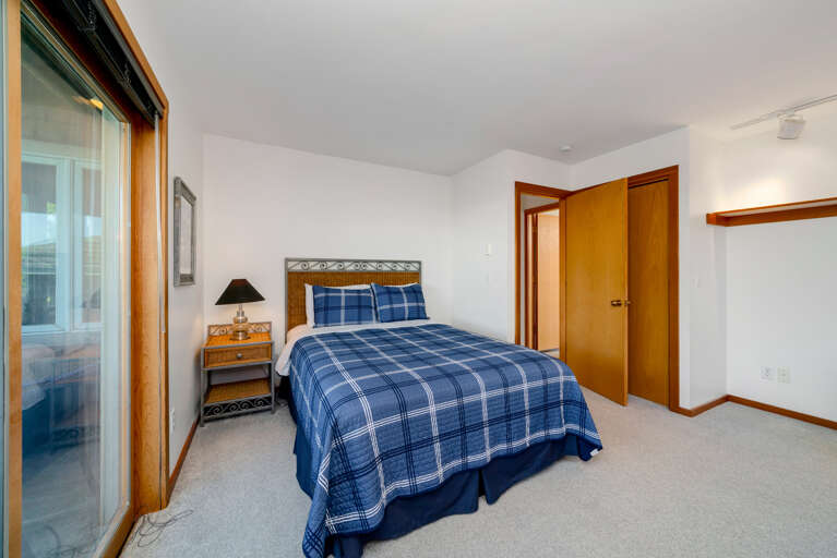 Lower bedroom with Queen bed and Ocean Views, outdoor deck, and deck furniture.