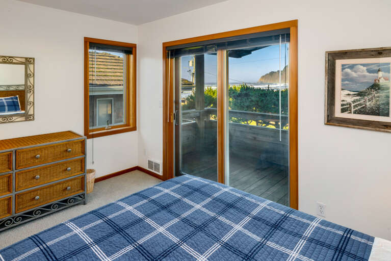 Lower bedroom with Queen bed and Ocean Views, outdoor deck, and deck furniture.
