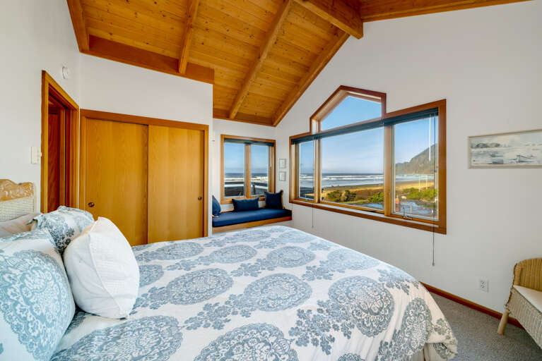 Upstairs master bedroom with Queen bed, ocean and mountain view, attached full bath and window sitting area.  .