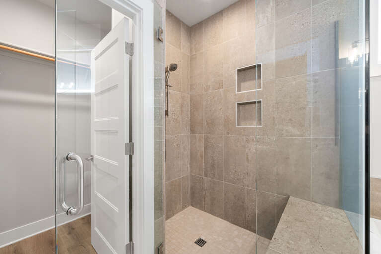 Master bathroom walk in shower with a seat bench