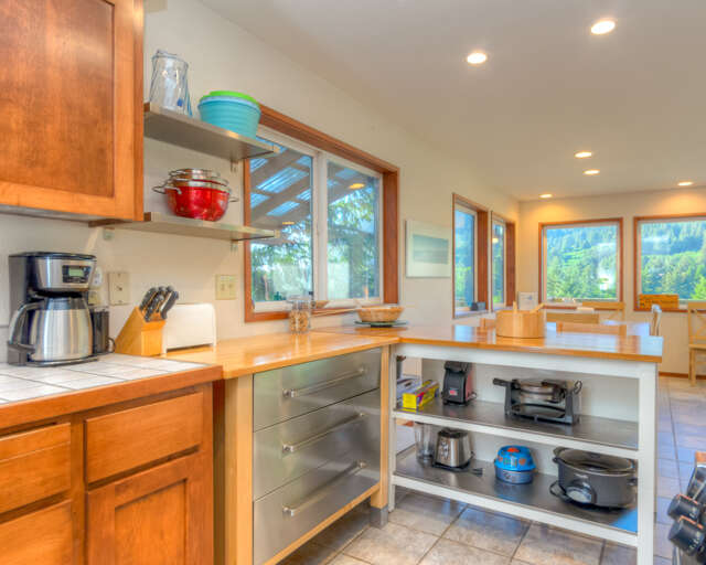 Fully equipped kitchen with access out to back deck with hot tub and outdoor dining area. Fully equipped kitchen with access out to back deck with hot tub and outdoor dining area.