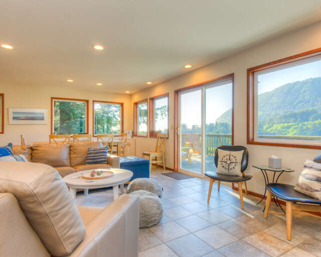 Living room with TV, wood fireplace and access to deck with mountain view.  Living room with TV, wood fireplace and access to deck with mountain view.
